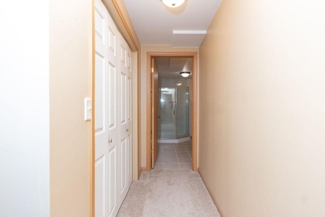 hallway with light colored carpet and baseboards