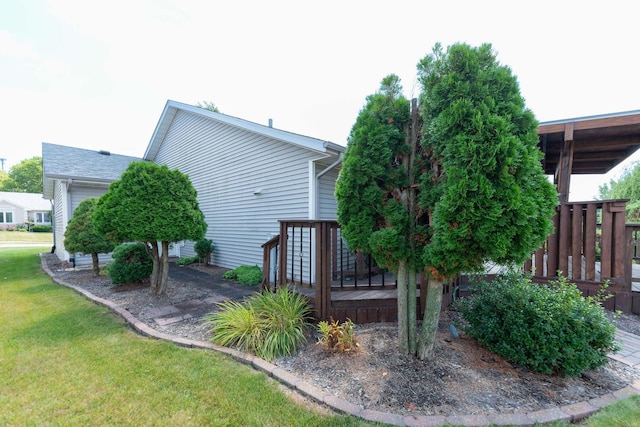 view of side of property with a lawn and a wooden deck