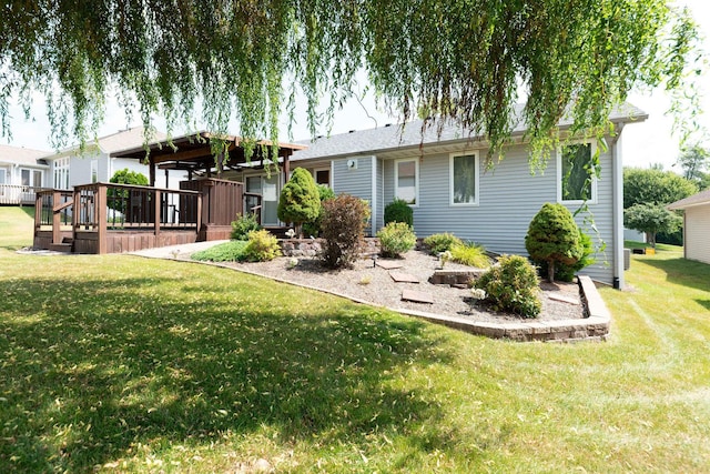 rear view of house featuring a lawn and a wooden deck