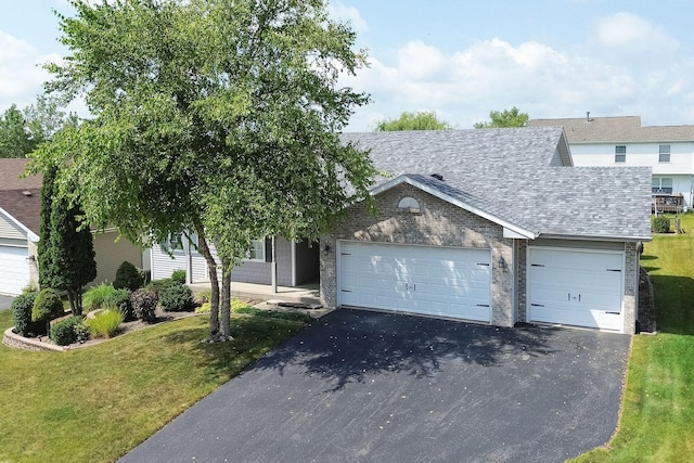 view of front facade with a shingled roof, a front lawn, a garage, aphalt driveway, and brick siding