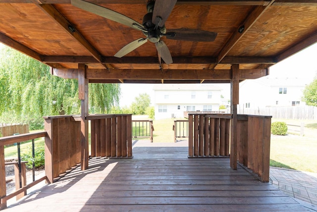 wooden deck with ceiling fan and fence