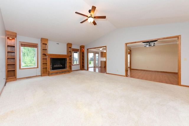 unfurnished living room with vaulted ceiling, plenty of natural light, a ceiling fan, and carpet floors