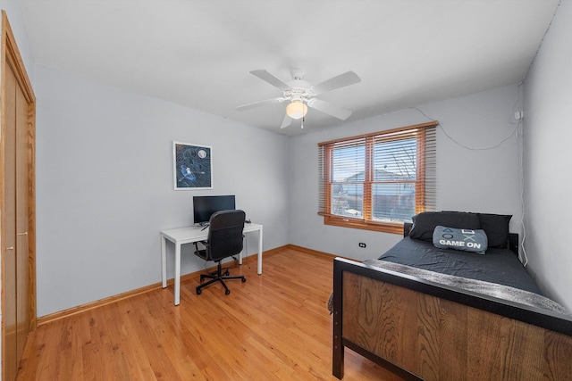 bedroom featuring a ceiling fan, light wood-type flooring, and baseboards