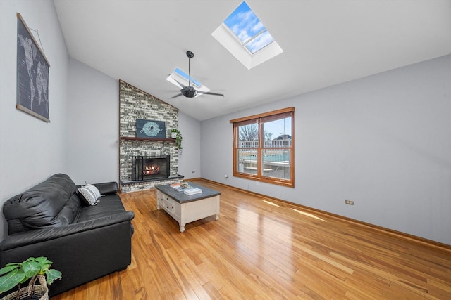 living room with a large fireplace, light wood-style floors, ceiling fan, and vaulted ceiling