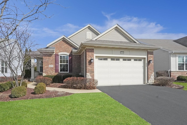 ranch-style house with brick siding, a front yard, aphalt driveway, and a garage