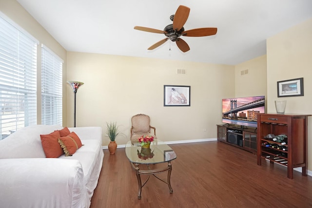 living area with a ceiling fan, visible vents, wood finished floors, and baseboards