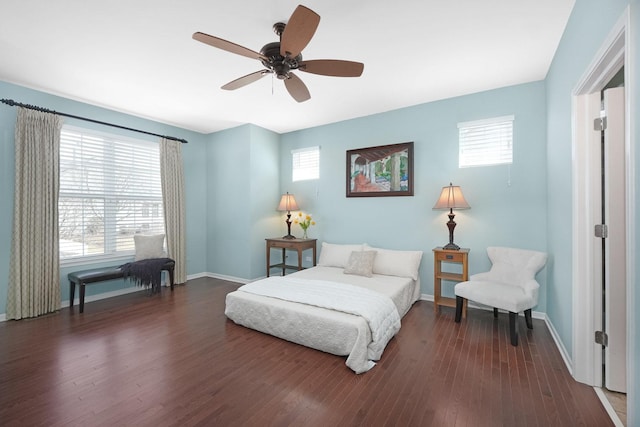 bedroom with dark wood finished floors, multiple windows, baseboards, and ceiling fan