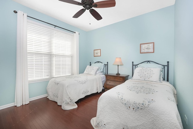 bedroom featuring baseboards, wood finished floors, and a ceiling fan