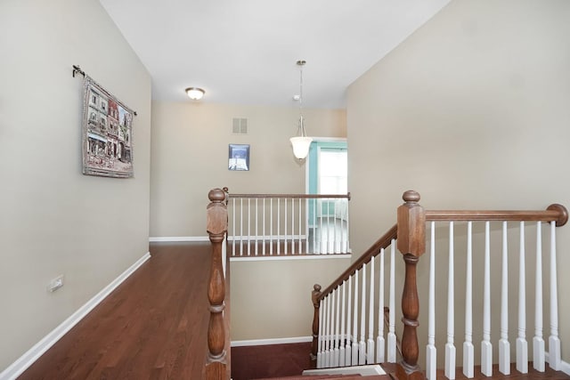 stairway with visible vents, baseboards, and wood finished floors