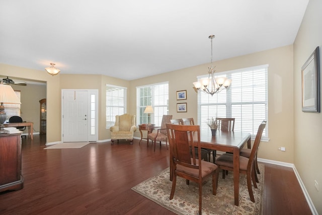 dining space with dark wood finished floors, a chandelier, and baseboards