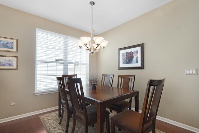 dining space with baseboards, a notable chandelier, and dark wood finished floors