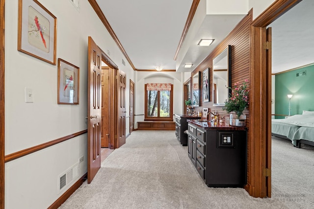 hall featuring light colored carpet, visible vents, and ornamental molding