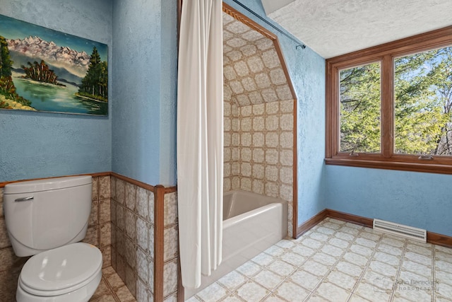 bathroom with tile patterned floors, toilet, a textured wall, and visible vents