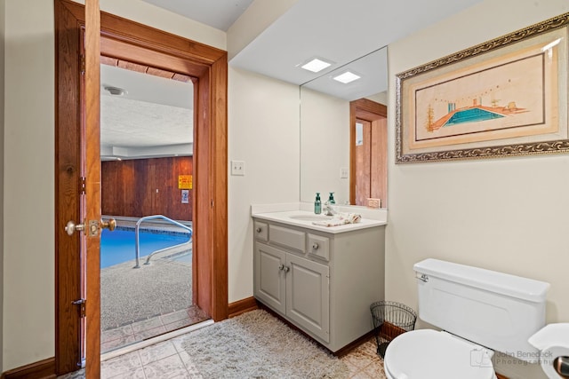 bathroom with toilet, vanity, and baseboards