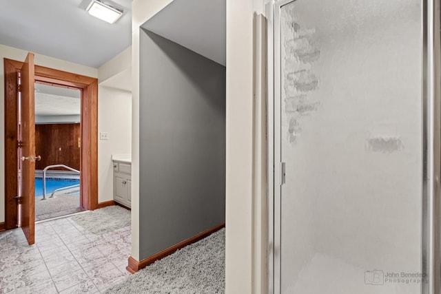 bathroom featuring baseboards, a stall shower, and vanity