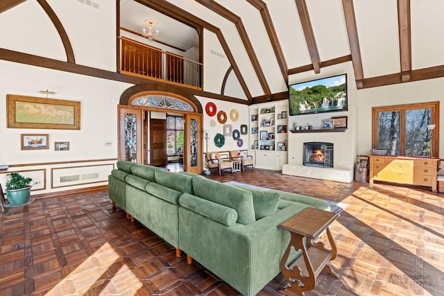 living room with visible vents, high vaulted ceiling, and a brick fireplace