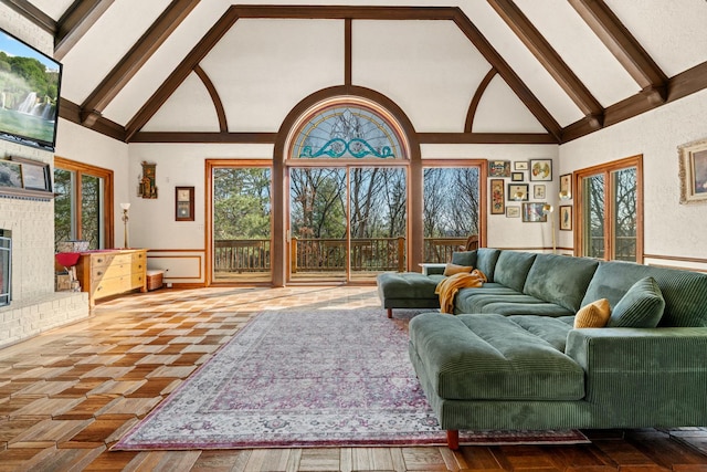 living area featuring beamed ceiling, a fireplace, and high vaulted ceiling