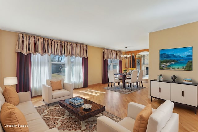 living room featuring light wood-type flooring and a notable chandelier