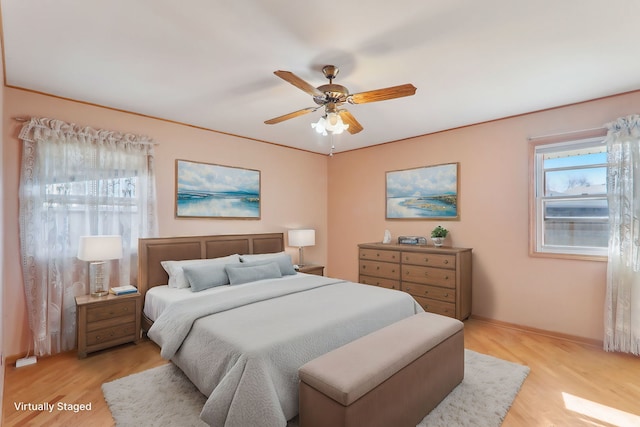 bedroom featuring ceiling fan, baseboards, and light wood-style floors