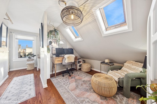 home office featuring baseboards, plenty of natural light, wood finished floors, and vaulted ceiling with skylight