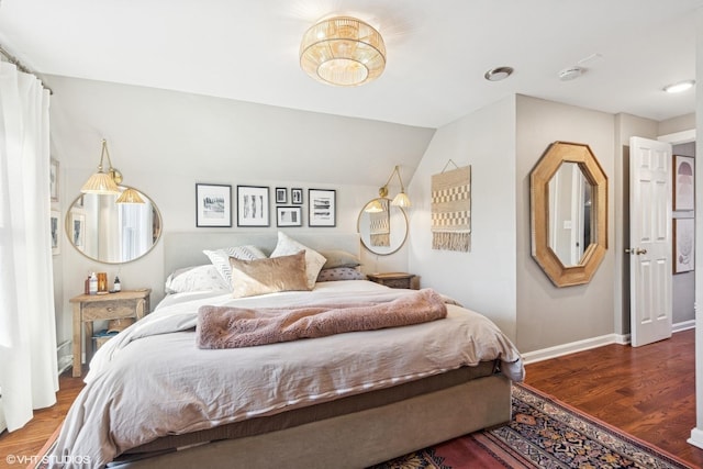 bedroom featuring vaulted ceiling, wood finished floors, and baseboards