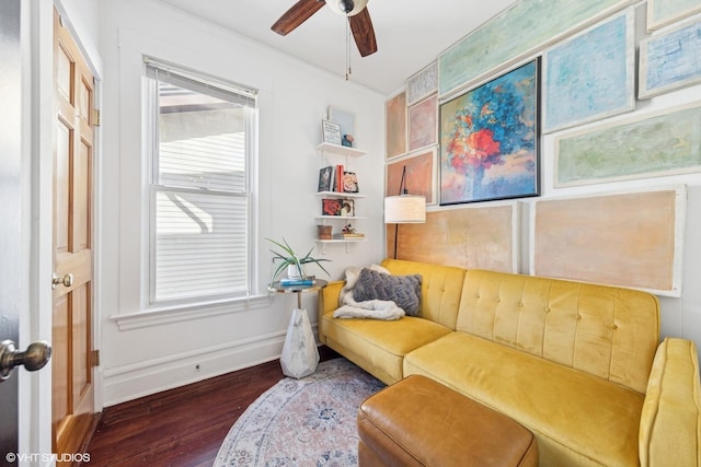 living area with a ceiling fan, wood finished floors, and baseboards