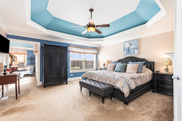 bedroom with ornamental molding, a tray ceiling, light colored carpet, and ceiling fan