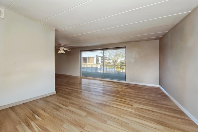 empty room featuring visible vents, light wood-style flooring, a ceiling fan, and baseboards