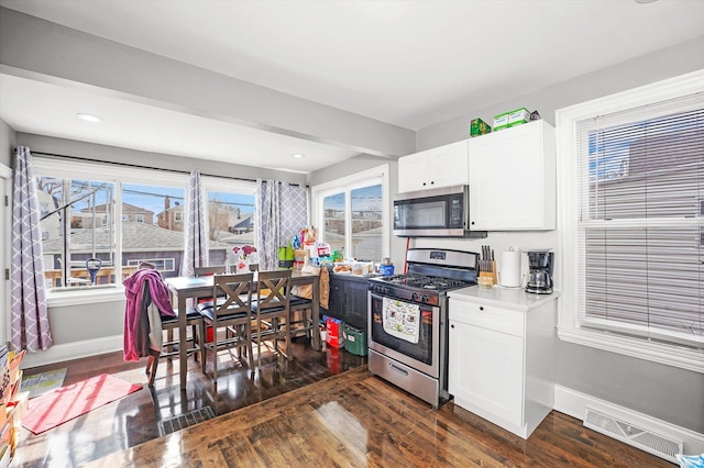 kitchen with visible vents, plenty of natural light, appliances with stainless steel finishes, and dark wood-type flooring