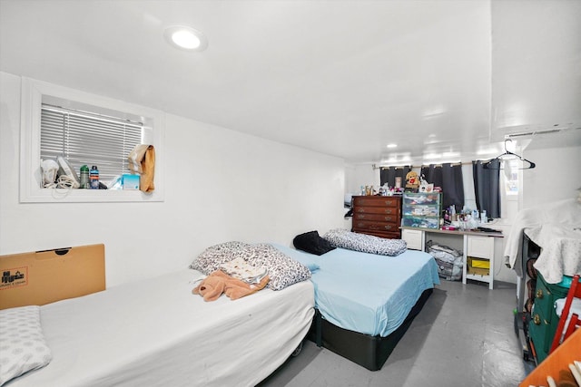 bedroom with recessed lighting and finished concrete flooring