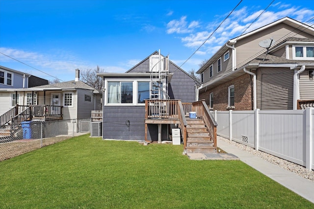 back of property with stairs, a lawn, and a fenced backyard