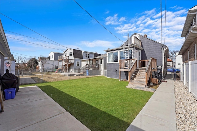 view of yard with a residential view, a fenced backyard, and a deck