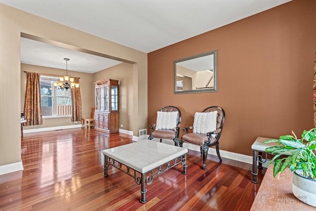 sitting room with visible vents, baseboards, an inviting chandelier, and dark wood-style floors