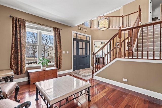 foyer entrance with hardwood / wood-style floors, stairway, and baseboards