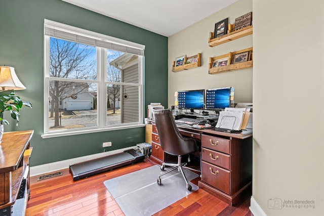 office featuring visible vents, baseboards, and wood-type flooring