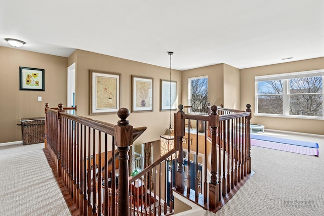 stairway with visible vents, carpet floors, and baseboards