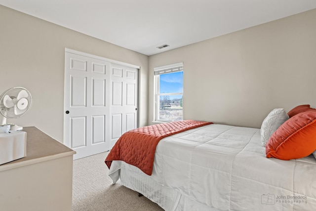 bedroom featuring a closet, visible vents, and carpet flooring