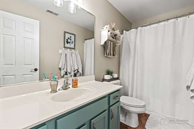 bathroom featuring visible vents, toilet, a shower with curtain, wood finished floors, and vanity