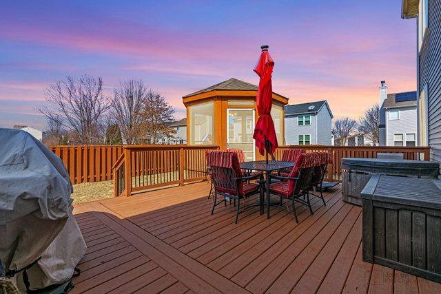 deck at dusk featuring outdoor dining space