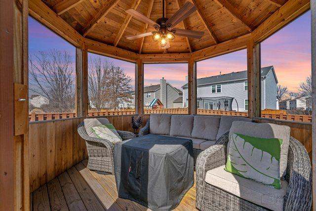 sunroom featuring wooden ceiling, lofted ceiling with beams, and a ceiling fan