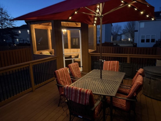 wooden deck featuring outdoor dining space and a sunroom