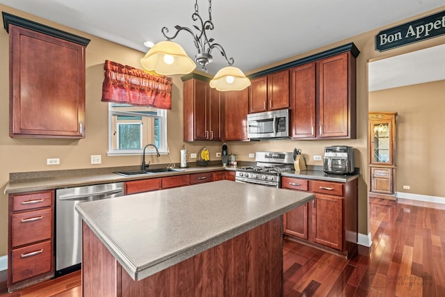 kitchen featuring a kitchen island, dark wood-style flooring, appliances with stainless steel finishes, and a sink