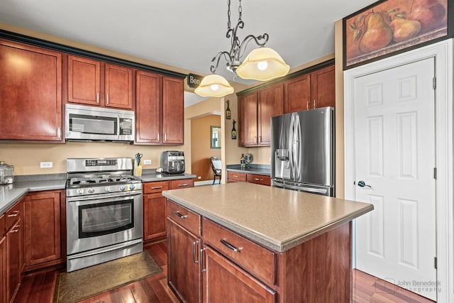 kitchen featuring dark wood-style floors, a center island, stainless steel appliances, and decorative light fixtures