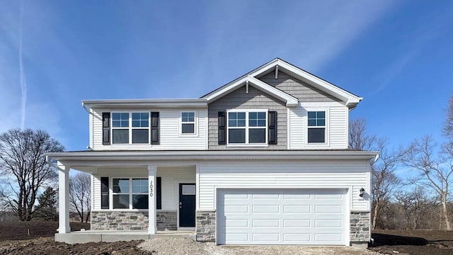 craftsman inspired home featuring a porch, a garage, and stone siding