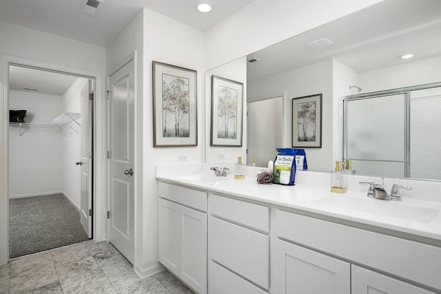 bathroom featuring a walk in closet, a shower stall, visible vents, and a sink