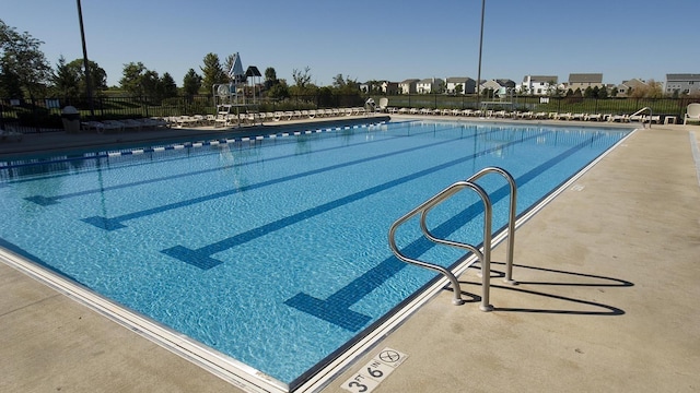 pool with a patio area and fence