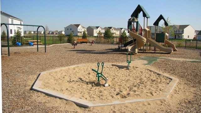 communal playground with a residential view and fence