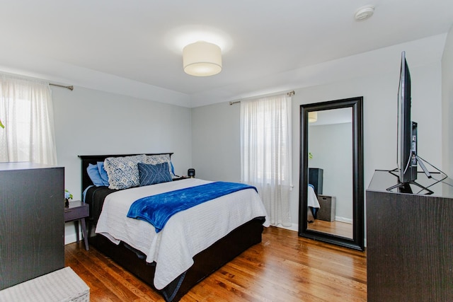 bedroom featuring multiple windows and wood finished floors