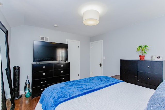 bedroom featuring vaulted ceiling, visible vents, and wood finished floors