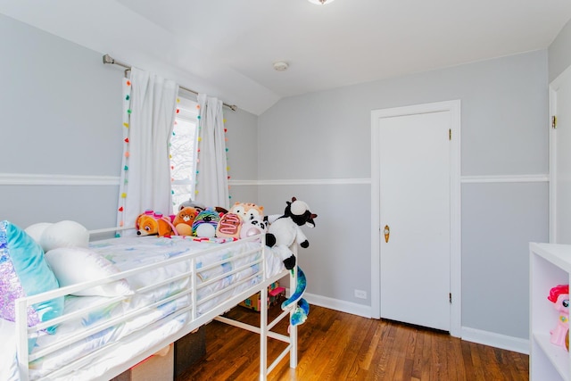 bedroom featuring lofted ceiling, wood finished floors, and baseboards